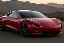 Red 2026 Tesla Roadster on mountain road at sunset.