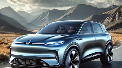 2026 Kia EV9 electric SUV parked on a scenic road with mountains in the background, featuring a sleek modern design and metallic blue color.